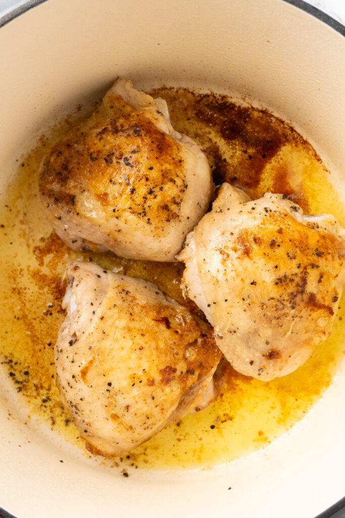 browned chicken thighs in a pot