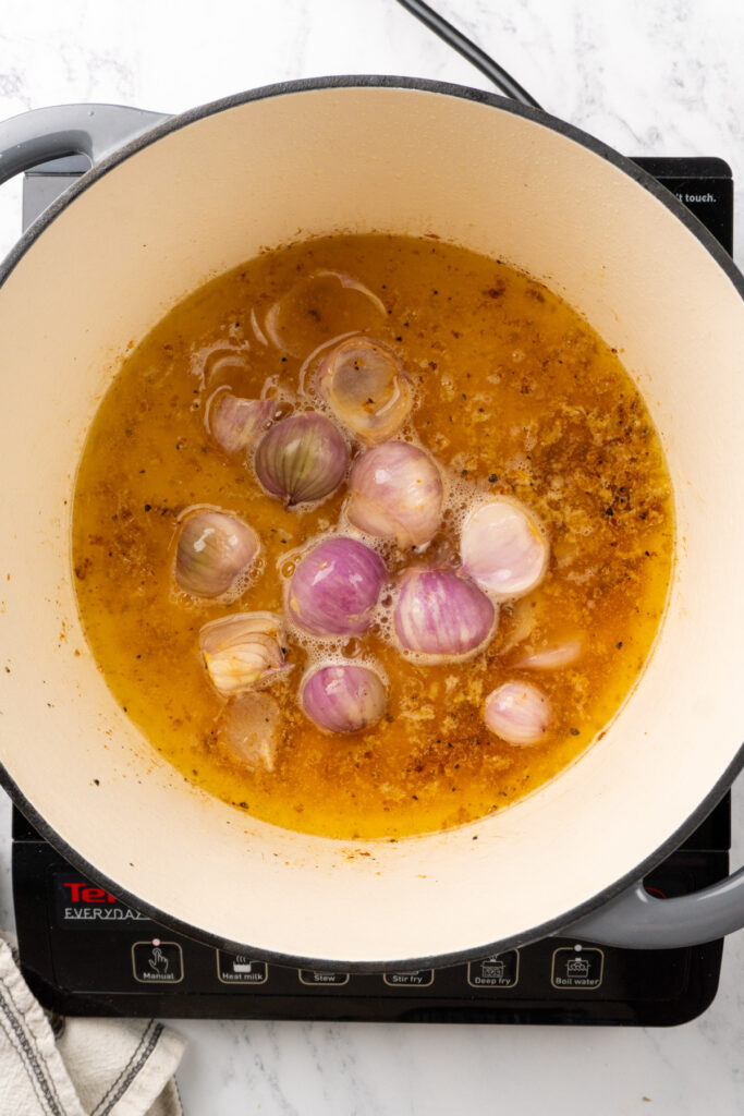 shallots and garlic in a Dutch oven with wine