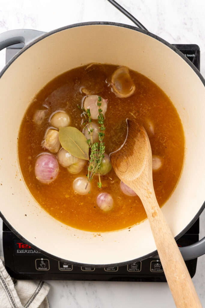 shallots and garlic in a Dutch oven and bay leaves