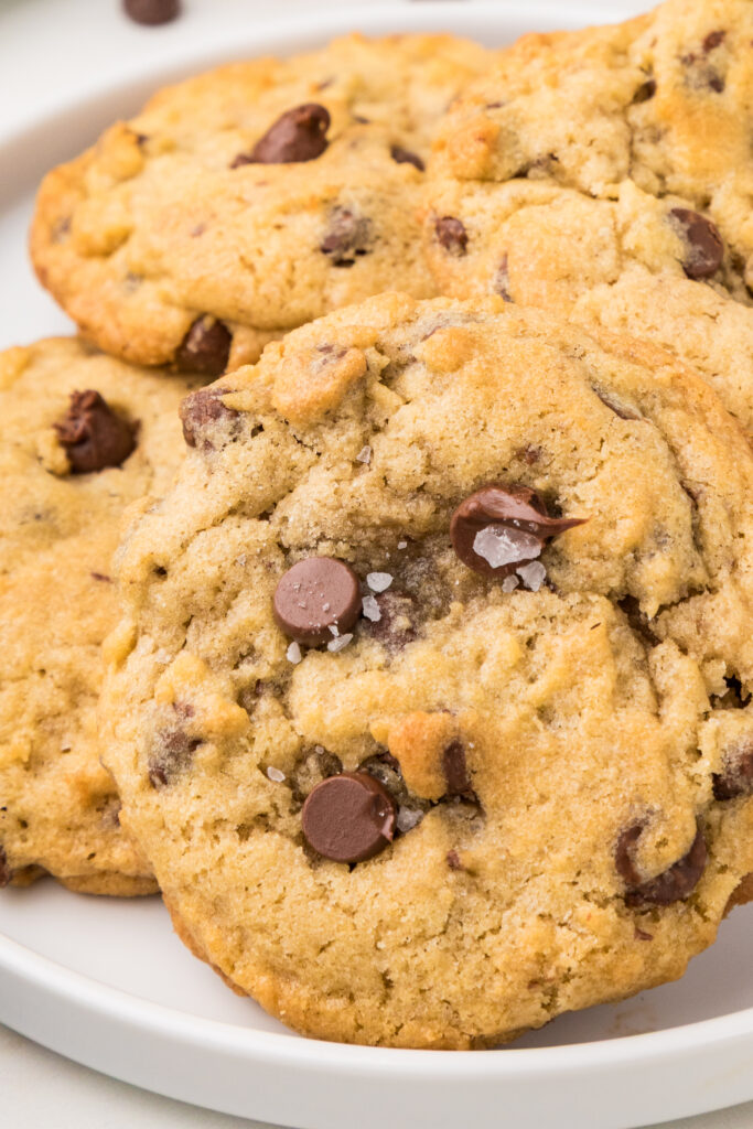 Soft and chewy chocolate chip cookies with golden edges and melty chocolate chips on a baking tray.