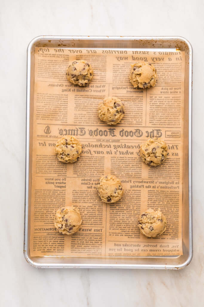 chocolate chip cookies lined up on a parchment paper