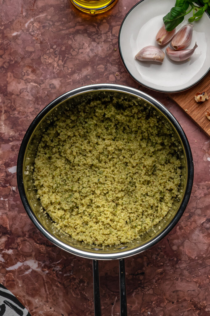 Close-up of couscous coated in green basil pesto