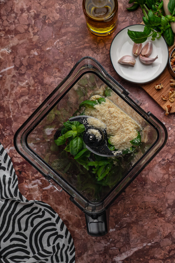 Fresh basil, walnuts, garlic, olive oil, and Parmesan in a blender