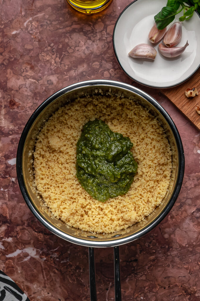 Close-up of couscous coated in green basil pesto
